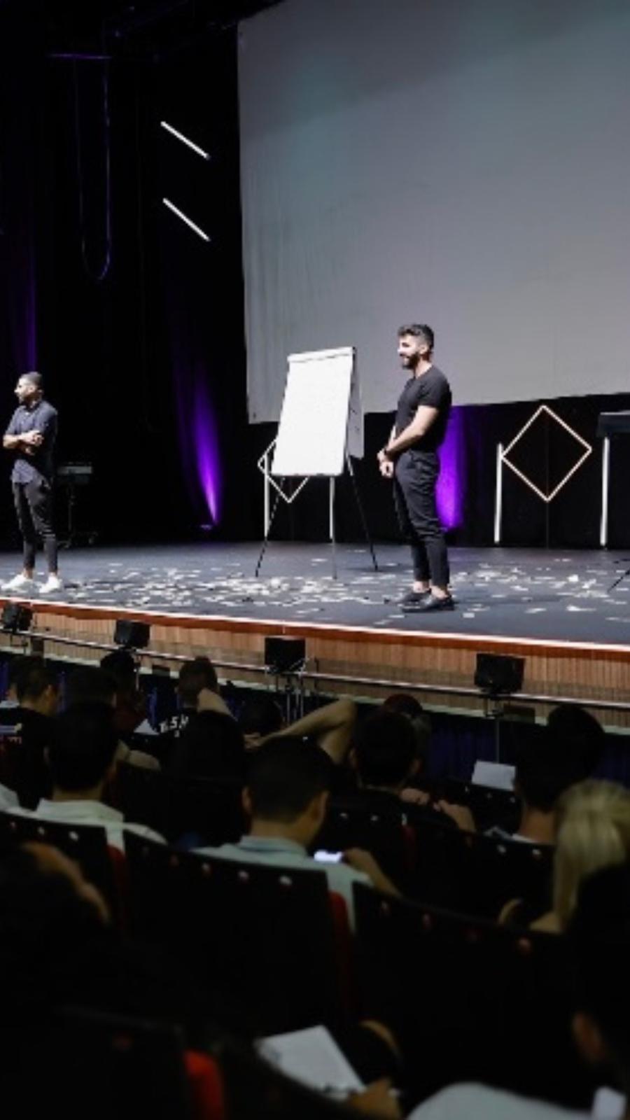 רם אלוס על במת סמינר גדול מול קהל